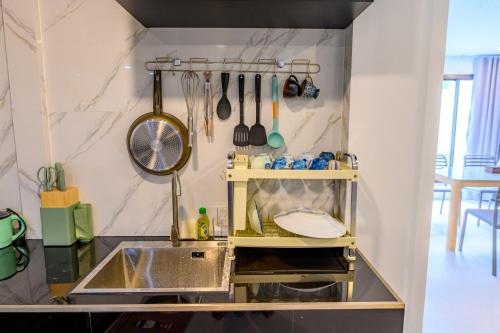 a kitchen with a sink and a shelf with utensils at Mountain View Escape at Primrose Hill in Bangrak Beach