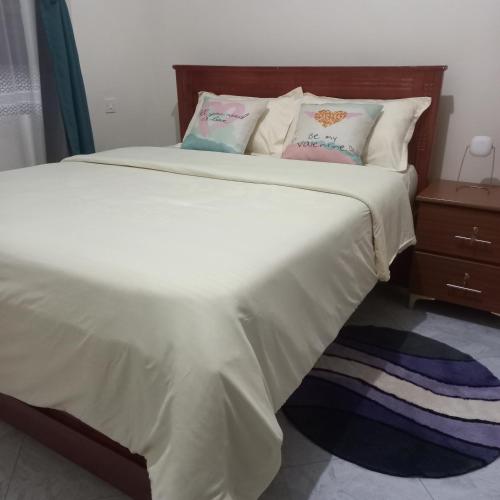 a bedroom with a large bed with white sheets and pillows at Celesta House in Mbarara