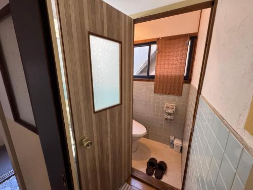 a small bathroom with a toilet and a mirror at Rooftop Camping Nagasaki-遊べるホステル-Seven-eleven3min in Nagasaki
