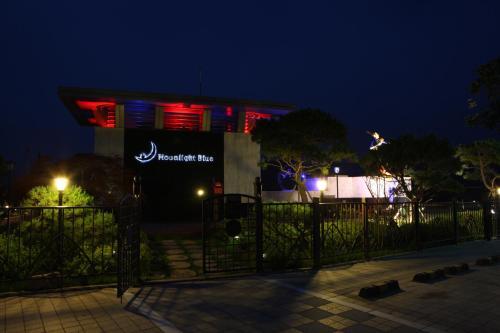 a building with a sign on it at night at Moonlight Blue Pension in Gapyeong