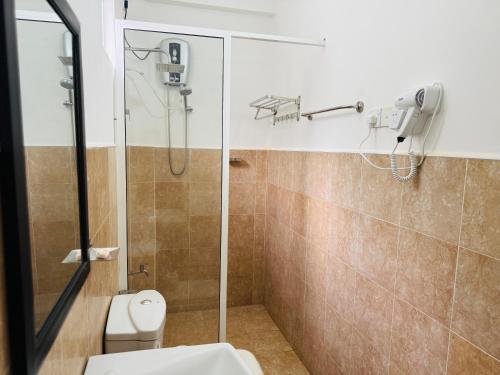 a bathroom with a shower and a toilet at Hotel sunflower in Dambulla