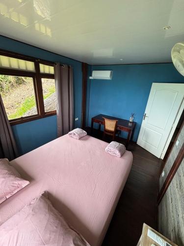 a bedroom with two beds and a table at Matira Hills Apartment in Bora Bora