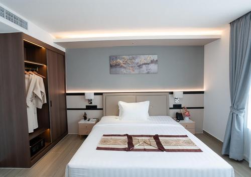 a bedroom with a large white bed and a closet at LN Hotel & Residence in Phnom Penh