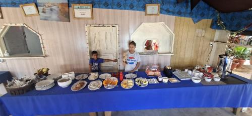 two people standing in front of a table with plates and bowls at DO NOT USE this in Apia