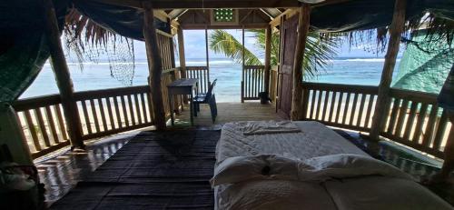 a bedroom with a bed in a room with the ocean at DO NOT USE this in Apia