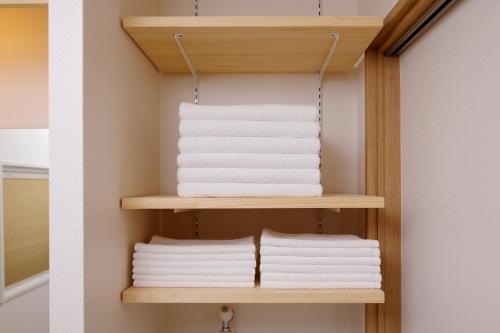 a stack of towels on a shelf in a bathroom at 桜ノ舎 in Nara