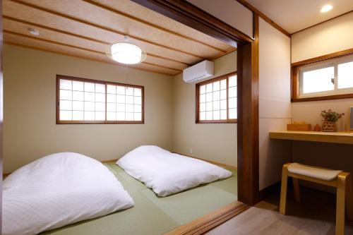 two beds in a room with two windows at 桜ノ舎 in Nara