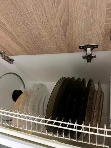 a shelf in a dishwasher with dishes in it at Квартира на Перемоги in Lutsk