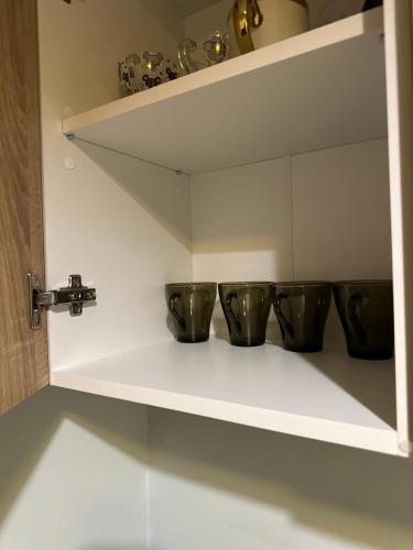 a shelf with four bowls on it in a kitchen at Квартира на Перемоги in Lutsk