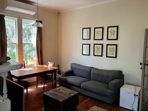 a living room with a couch and a table at Nothing Fancy 90s Queen Room in Whanganui