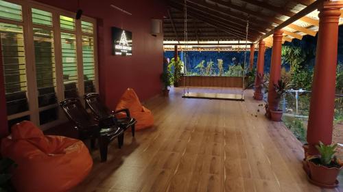 an empty room with chairs and a large window at Aksha Homestay in Sakleshpur