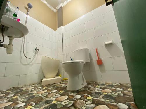 a bathroom with a toilet and a sink at Ibu ana quest house in Tabanan