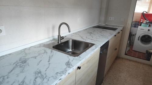 a kitchen with a sink and a counter top at Ocean front apartment Trianon in Daimuz