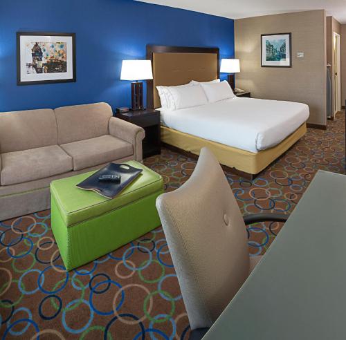 a hotel room with a bed and a couch at Holiday Inn Express Hotel & Suites Manchester - Airport by IHG in Manchester