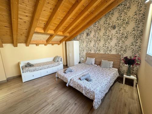 a bedroom with two beds and a wooden ceiling at Apartamentos San Nicolás AIRE AC y ascensor junto a Laurel in Logroño