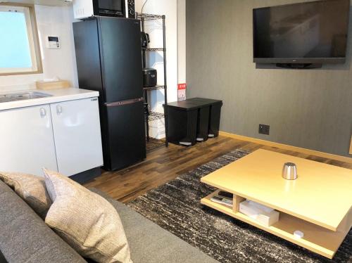 a living room with a couch and a coffee table at Chill Inn Honan by Tranova in Tokyo