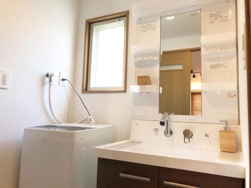 a bathroom with a sink and a mirror at Chill Inn Honan by Tranova in Tokyo