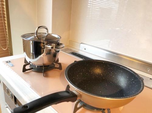 a pan on a stove with a pot on it at Chill Inn Honan by Tranova in Tokyo