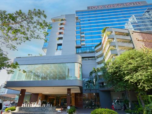 a tall building with a sign on it at The Four Wings Hotel Bangkok in Bangkok