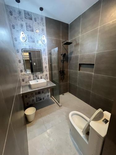 a bathroom with a sink and a toilet and a mirror at Maywood Private Resort in Calamba