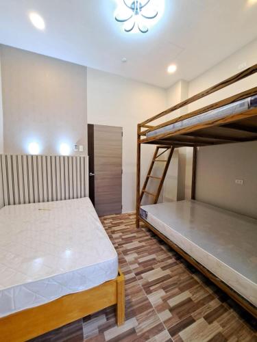 two bunk beds in a room with a chandelier at Maywood Private Resort in Calamba