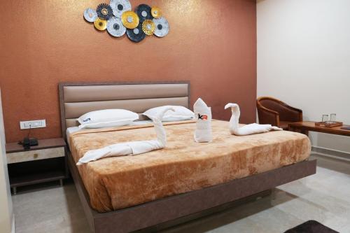 two swans sitting on a bed in a bedroom at Kailash Residency in Hospet