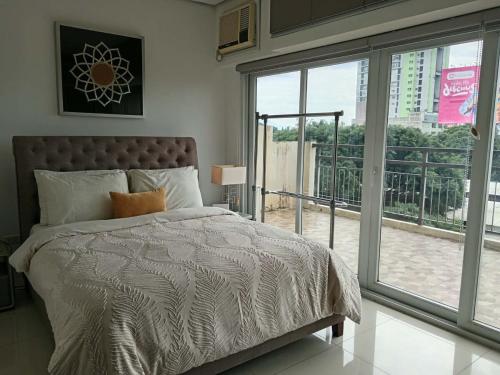 a bedroom with a bed and a large window at Sweet Escape 22 at O Residences in Bacolod