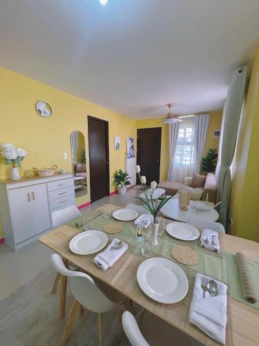 a dining room table with white plates on it at Casa Solana at Malaybalay VCDU Phase 3 B4 L22 in Malaybalay