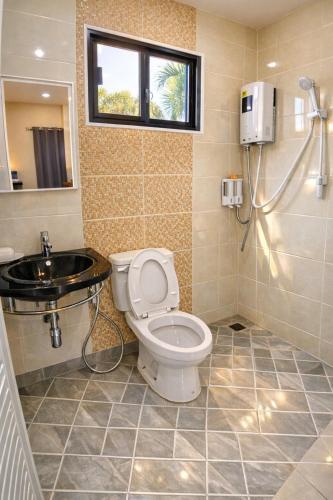 a bathroom with a toilet and a sink at วลัญชญ์ โฮเทล ศรีราชา in Ban Nong Chaeng