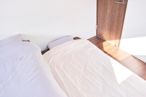 a bedroom with two beds and a mirror at Base Hanegi Apartment by Tranova in Tokyo