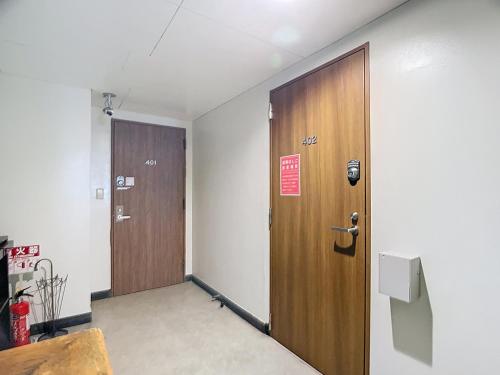 an empty room with a wooden door and a wall at キュリナリーBed and Art in Hamamatsu