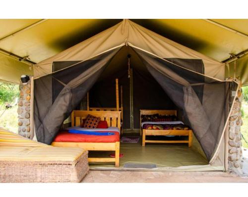 a tent with two beds in it at Oloimala Mara Camp in Gatunga