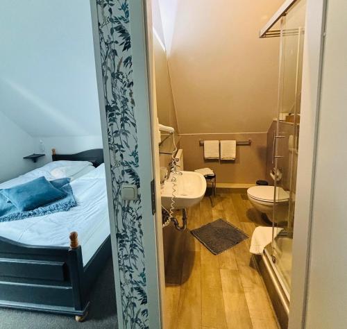a bathroom with a bed and a sink and a toilet at Am Wasserturm Pension in Bad Muskau