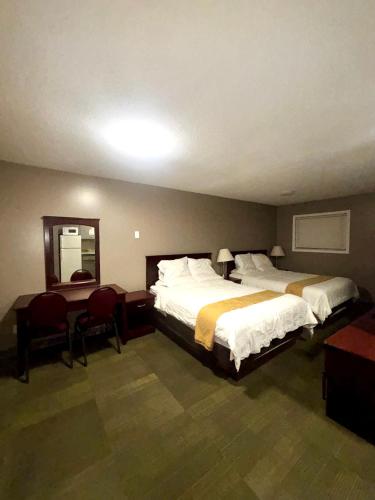 a hotel room with two beds and a table and chairs at Rainbow INN in Terrace