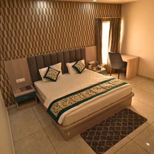 a bedroom with a bed with a chair and a window at Mithila Resort in Jāmb