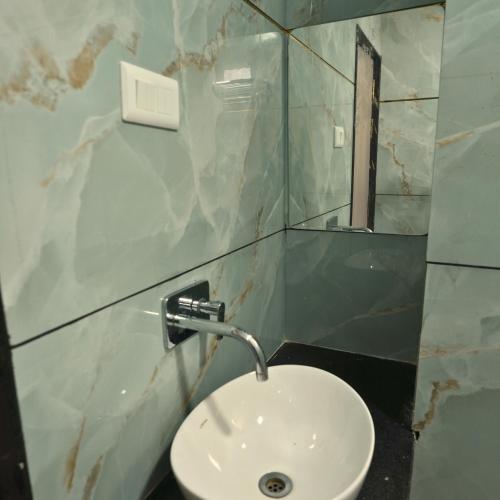 a bathroom with a white sink and a mirror at Mithila Resort in Jāmb