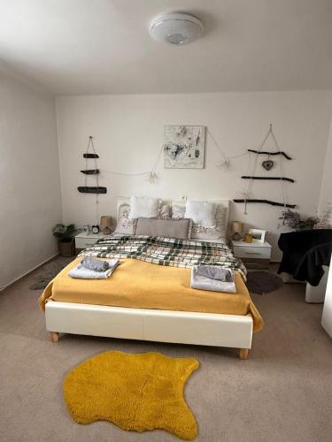 a bedroom with a large bed with a yellow blanket at Ubytovanie Dana in Piešťany