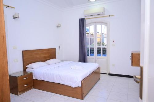 a bedroom with a large bed and a window at Qasr El Nil in Luxor