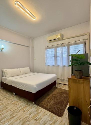 a bedroom with a large bed and a window at Saan Stay in Ban Krabi Yai