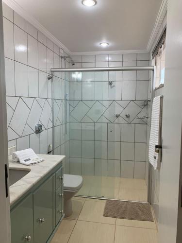 a bathroom with a shower with a toilet and a sink at Suíte de Casal Privativa com Sacada in Sao Jose do Rio Preto