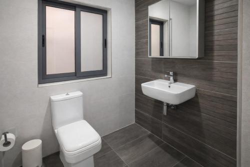 a bathroom with a white toilet and a sink at Modern Double Room in Peaceful Pembroke just Minutes away from St Julians in Pembroke