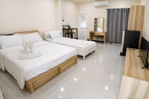 a bedroom with two beds and a television in it at วลัญชญ์ โฮเทล ศรีราชา in Ban Nong Chaeng