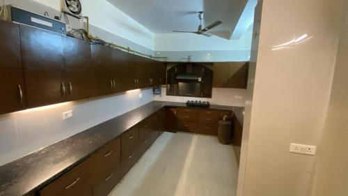 a kitchen with wooden cabinets and a ceiling at Mitron Farms in New Delhi