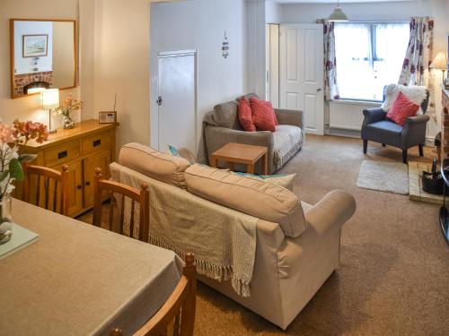 a living room with a couch and a table at Maydrift in Mundesley