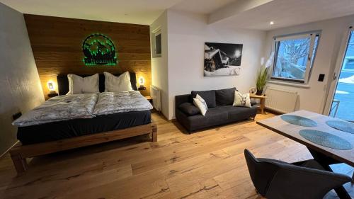 a bedroom with a bed and a couch and a table at Tauernchalet-S'Hoamatl in Hollersbach im Pinzgau