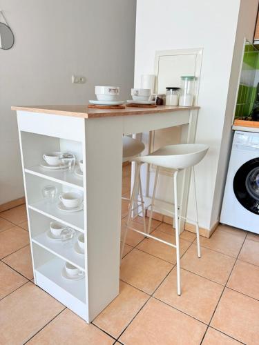 a kitchen island with a counter with dishes on it at Le Petit Oasis à Saint-Denis in Saint-Denis