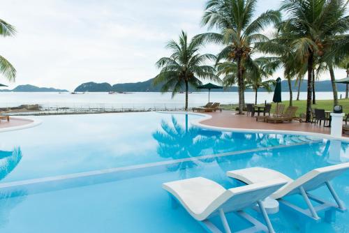 einen Pool mit Stühlen und Meerblick in der Unterkunft The Ocean Residence Langkawi in Kuah