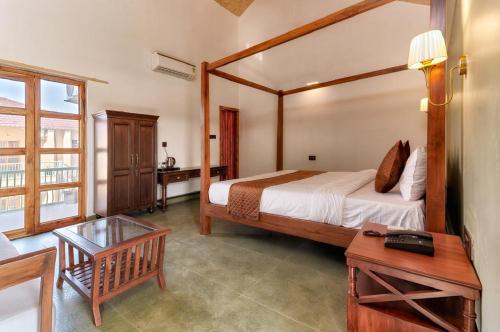 a bedroom with a large bed and a table at The Bagh Villa Pench By Ficusroots Experience in Khawāsa