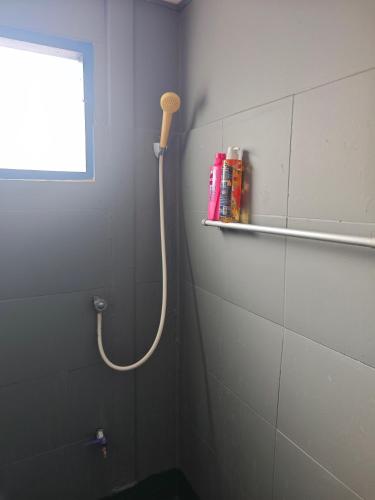 a bathroom with a shower hose on the wall at Worsakornrit Homestay in Bangkok