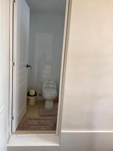 a bathroom with a white toilet in a room at Tikawasi Homestay Comunidad Pueblo Isla Amantani José Luis in Ocosuyo